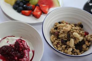 a bowl of granola and berries next to a plate of fruit at The Waves in Scarborough