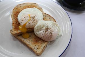 a white plate with two eggs on top of toast at The Waves in Scarborough