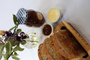 a loaf of bread on a cutting board with a bottle of honey at The Waves in Scarborough