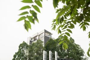 een gebouw bovenop enkele bomen bij CONJIOO HOTEL at JAKARTA AIRPORT in Tangerang