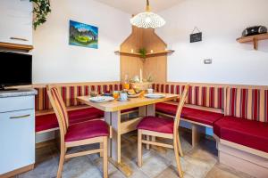 una sala da pranzo con tavolo in legno e sedie rosse di Niederkoflhof Klausberg a Cadipietra