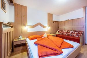una camera da letto con un letto con cuscini arancioni di Niederkoflhof Klausberg a Cadipietra