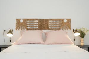 1 dormitorio con 1 cama blanca y 2 almohadas rosas en CASA PALACIO SUR II, en El Puerto de Santa María