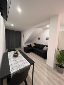 - un salon avec un canapé noir et une table dans l'établissement OPO - Fantastic studio with garden, à Porto