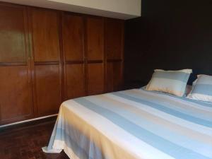 a bedroom with a large bed with wooden cabinets at Departamento Lorenzo I in Mendoza