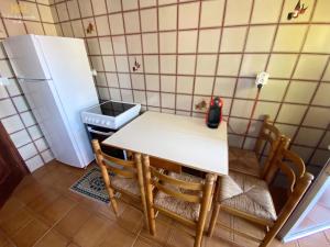 cocina con mesa, sillas y nevera en La Casa de Lalo, en Castrillón