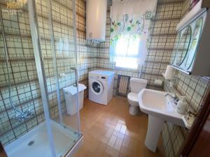 uma casa de banho com um lavatório e uma máquina de lavar roupa em La Casa de Lalo em Castrillón