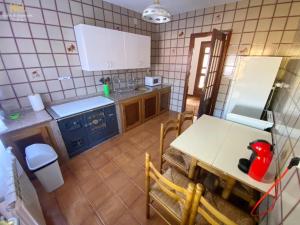 una cocina con armarios azules, una mesa y un tocador en La Casa de Lalo, en Castrillón