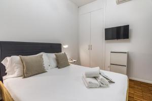 een slaapkamer met een wit bed en een flatscreen-tv bij BePlace Apartments in Isola in Milaan