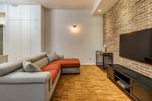 a living room with a couch and a flat screen tv at BePlace Apartments in Isola in Milan