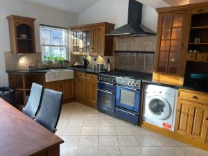 a kitchen with a stove and a washing machine at Beautiful Traditional English 4 bedroom home in Greenwich in Plumstead