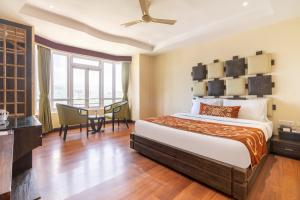 a hotel room with a bed and a table at Summit Lillium Hotel & Spa in Kalimpong