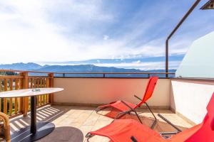 balcón con mesa, sillas y montañas en Hotel Amaten en Brunico