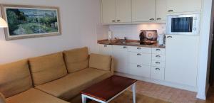 a living room with a couch and a kitchen at Sylter-Besserburg-App-7 in Westerland (Sylt)
