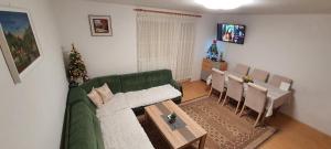 un soggiorno con divano verde e tavolo di Vikendica Jovanovic a Foča