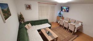 ein Wohnzimmer mit einer grünen Couch und einem Tisch in der Unterkunft Vikendica Jovanovic in Foča