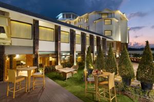 an exterior view of a hotel with tables and chairs at Vivanta Meghalaya Shillong in Shillong