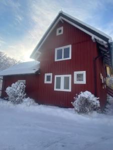 a red barn with snow on the ground in front of it at Fischer Hütte in Sankt Andreasberg