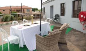 a white table and chairs on a balcony with a table and chairs at D'Villa Rest Inn in Gaborone