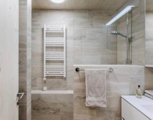 een badkamer met een douche, een bad en een wastafel bij Apartment Klausbrücke in Mellau +69 foto's