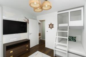 een woonkamer met een tv en een boekenplank bij Mövenpick Balaland Resort Lake Balaton in Szántód