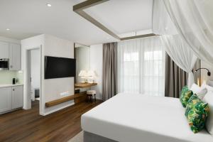 Habitación de hotel con cama y TV en Mövenpick Balaland Resort Lake Balaton en Szántód