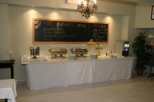 a counter in a restaurant with a chalkboard on the wall at Hotel Gloria Budapest City Center in Budapest