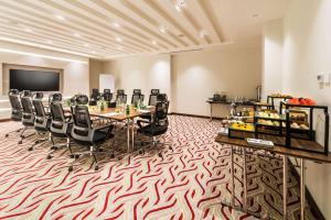 Best Western Plus Al Qurayyat City Center في القريّات: قاعة المؤتمرات مع طاولة وكراسي طويلة