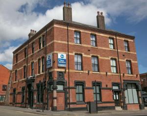 a red brick building on the corner of a street at Best Western Hotel 99 in Blackburn