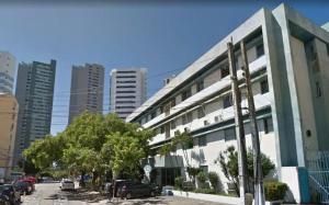 un gran edificio blanco con coches estacionados frente a él en Lindo APARTAMENTO com Varanda à 100m - Praia de BOA VIAGEM, en Recife