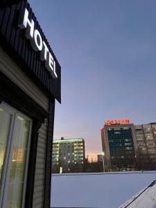 een Hilton bord aan de zijkant van een gebouw met een skyline van de stad bij Hotel NOMAD in Aqtöbe