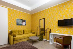 a living room with a yellow couch and a tv at Bogorodsk Ekotel in Noginsk