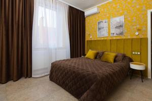 a bedroom with a large bed with yellow pillows at Bogorodsk Ekotel in Noginsk