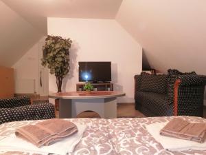 Un dormitorio con una cama, un televisor y una mesa. en SIMIĆ planinska kuća, en Divčibare