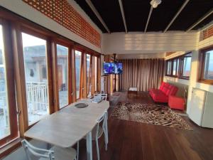 - un salon avec une table et un canapé rouge dans l'établissement Kost or Pasutri Rooftop Pogung Dalangan Sleman, à Kejayan