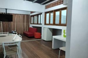 - un salon avec une table et une chaise rouge dans l'établissement Kost or Pasutri Rooftop Pogung Dalangan Sleman, à Kejayan