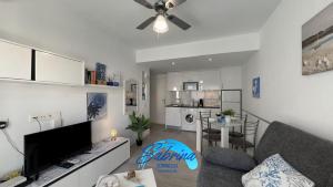 salon z kanapą i telewizorem z płaskim ekranem w obiekcie Grazioso appartamento al Bristol Sunset Vista w Corralejo