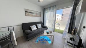 salon z kanapą i stołem w obiekcie Grazioso appartamento al Bristol Sunset Vista w Corralejo