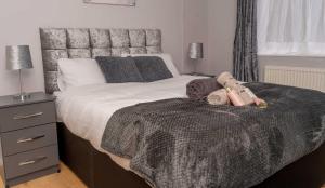 a bedroom with a bed with a teddy bear on it at Lovely Home in Coventry in Coventry