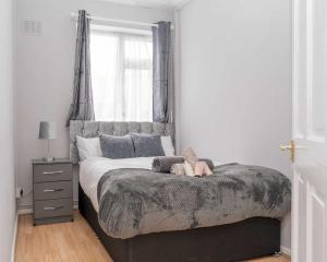 ein Schlafzimmer mit einem Bett mit einem ausgestopften Tier darauf in der Unterkunft Lovely Home in Coventry in Coventry