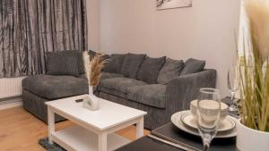 uma sala de estar com um sofá e uma mesa em Lovely Home in Coventry em Coventry