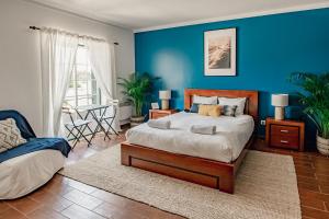 1 dormitorio con cama y pared azul en In My House Baleal en Baleal