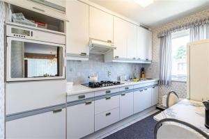 een keuken met witte kasten en een fornuis met oven bij SUPERB FLAT WITH 3 BEDROOMS PARKING AND BALCONy in Antwerpen