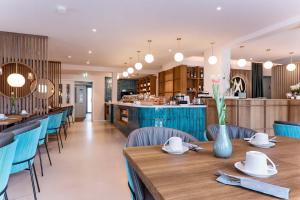 un comedor con mesas de madera y sillas azules en Astra Maris Apartments, en Büsum