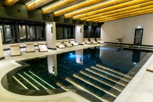 Statjunea BorsaHotel Roman Maramures - Ski & Spa Resort的一座带桌椅的游泳池