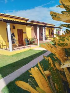 a house with a bunch of banana plants in front of it at Vila Vintém Chalés in Praia de Moitas