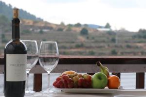 un plato de fruta y dos copas de vino en una mesa en עיינות ספיר - Einot Sapir, en Sappir