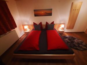 1 cama roja en una habitación con 2 lámparas en Schafferhäusl, Ferienwohnung, en Tux