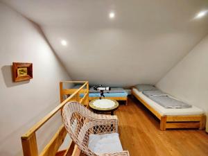 a attic room with a bed and a chair at Chatka Pod Trohańcem in Lutowiska