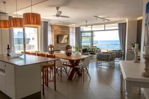 uma cozinha e sala de jantar com vista para o oceano em 406 Les Mouettes em Ballito